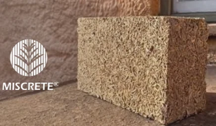 Small Miscrete block made with visible miscanthus fibre, shown with the Miscrete logo